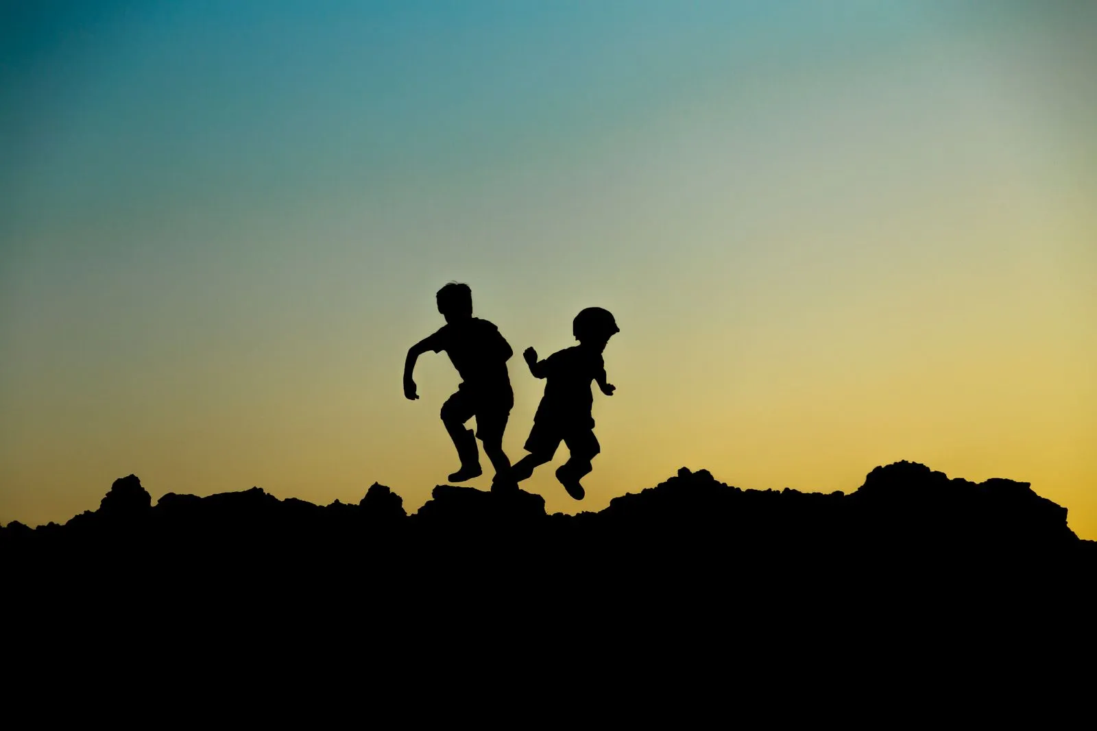 Dos infants jugant a l'aire lliure al capvespre durant l'estiu